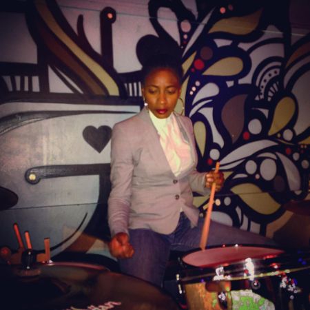 Ameenah Kaplan is looking at her drums.